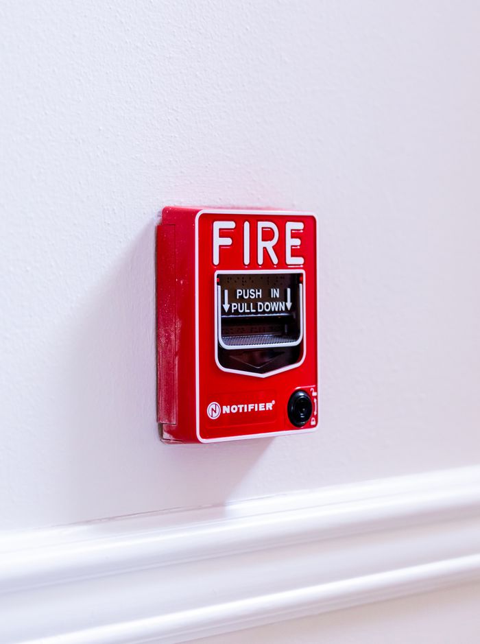 Home Close-up view of a red fire alarm switch with clear text instructions on a white wall.